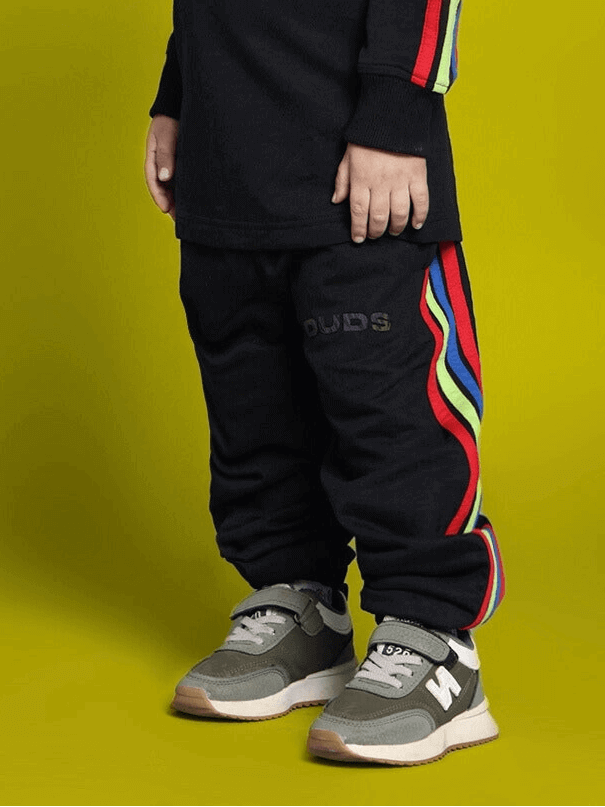 Child wearing black rainbow co-ord set by DUDS, featuring colorful stripe details on sleeves and pants, ideal for boys and girls.