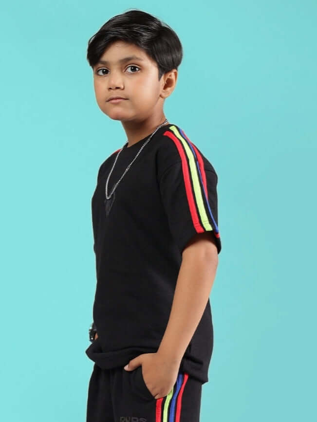 Boy wearing RAINBOW OVERSIZED T-SHIRT FOR BOYS & GIRLS BLACK with colorful stripes on sleeves