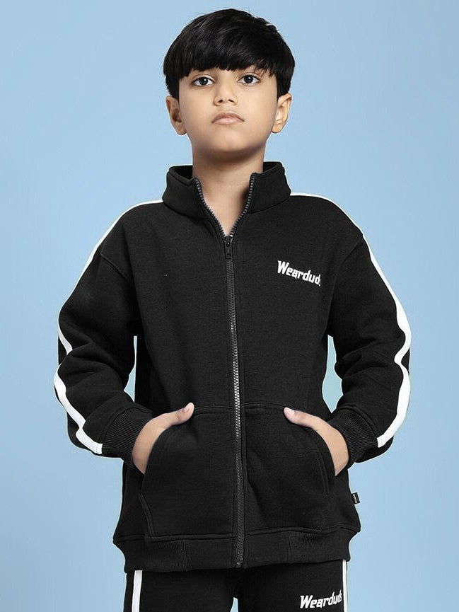 Child wearing Rapid Stride Fleece Jacket for Boys and Girls Black with sporty design and white accents, hands in pockets.