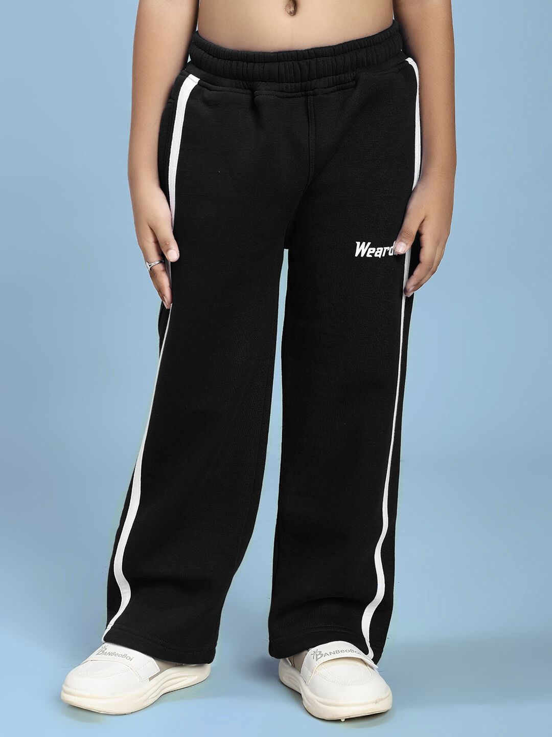 Child wearing RAPID STRIDE FLEECE JOGGER FOR BOYS AND GIRLS BLACK with white stripe detail, paired with white sneakers.