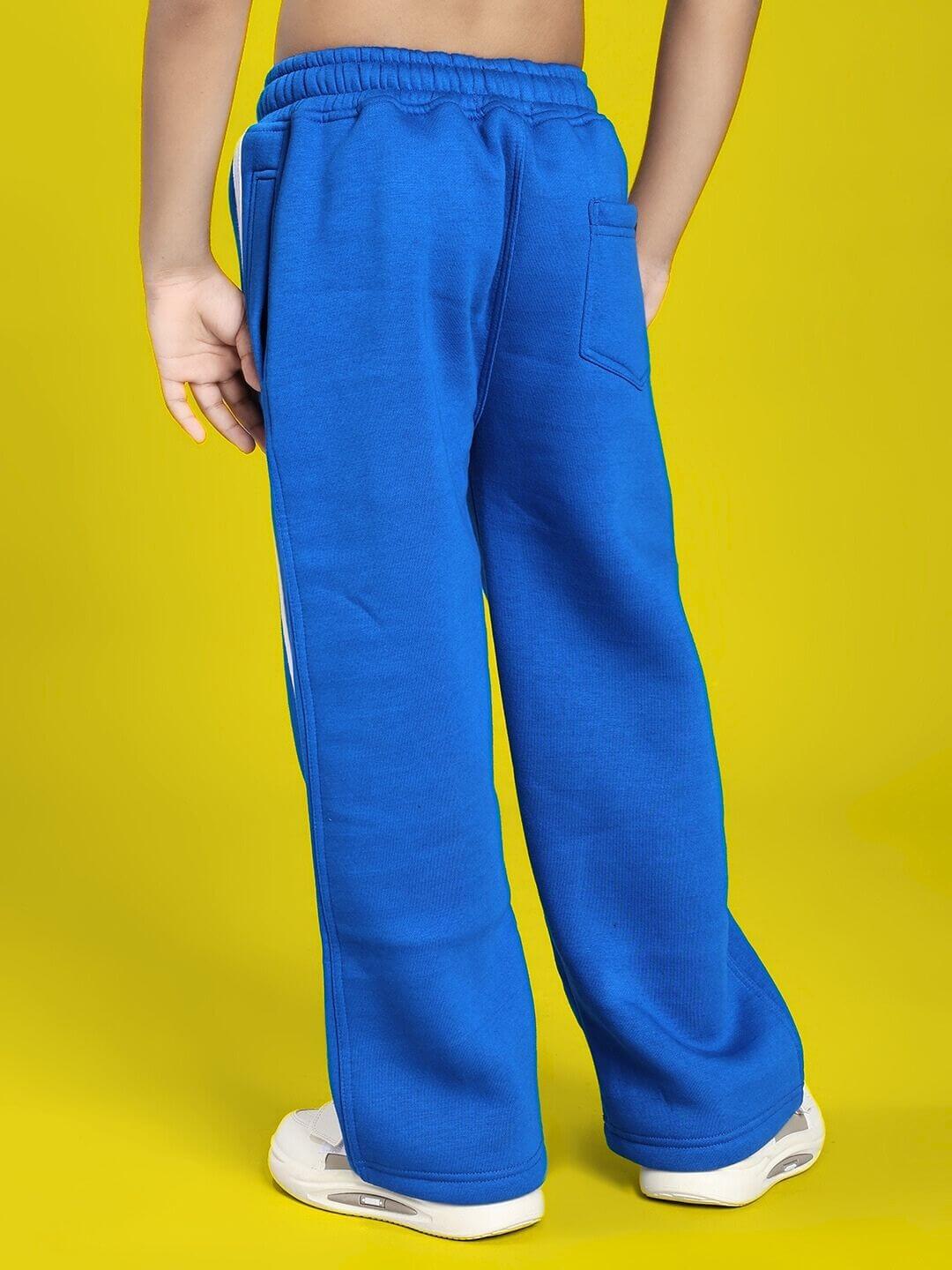 Child wearing RAPID STRIDE FLEECE JOGGER FOR BOYS AND GIRLS ROYAL BLUE, showing back view against yellow background.