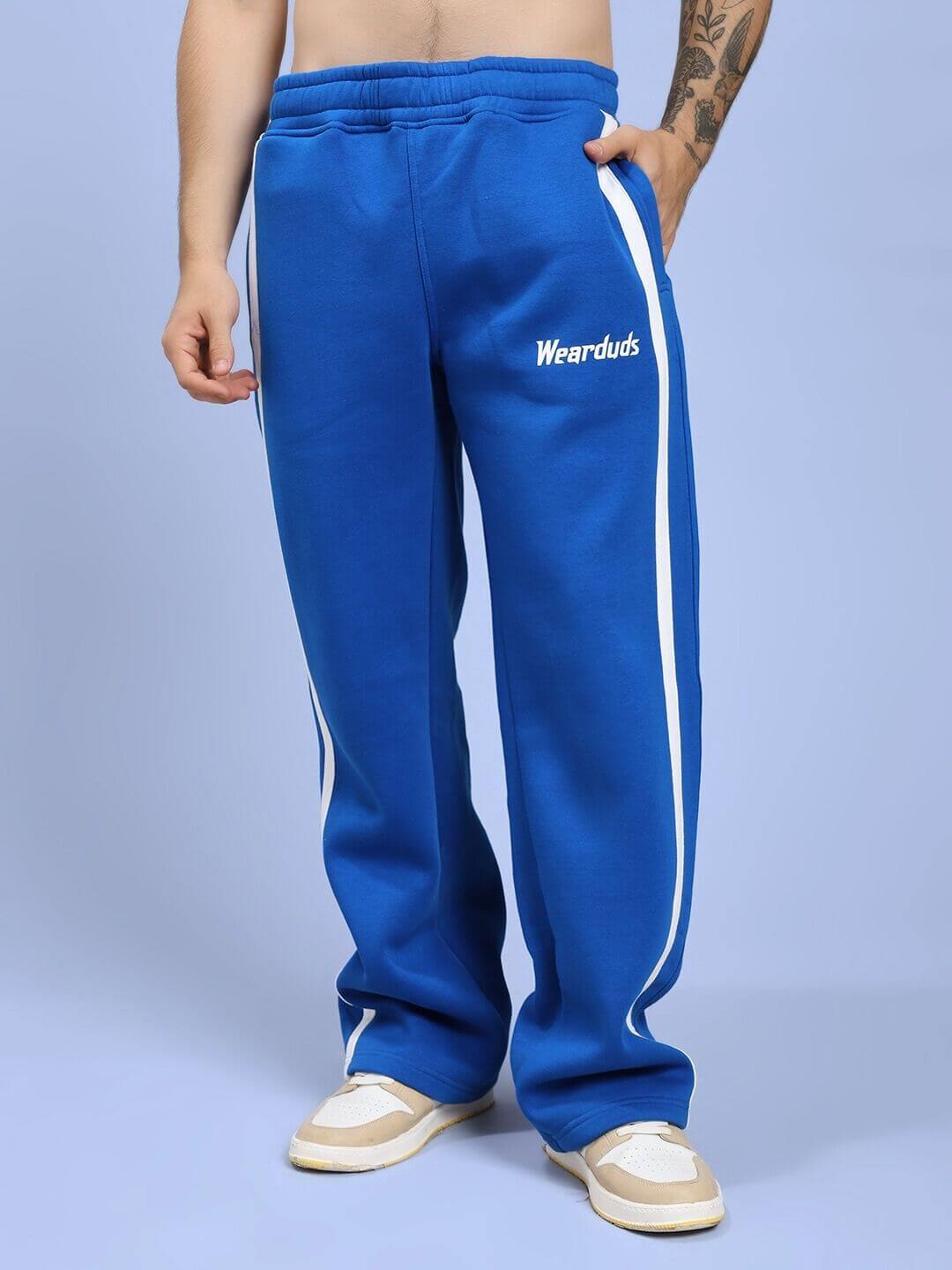 Model wearing Rapid Stride Royal Blue Cotton Fleece Co-ord Set, showcasing vibrant blue tracksuit pants with white stripes and logo detail.