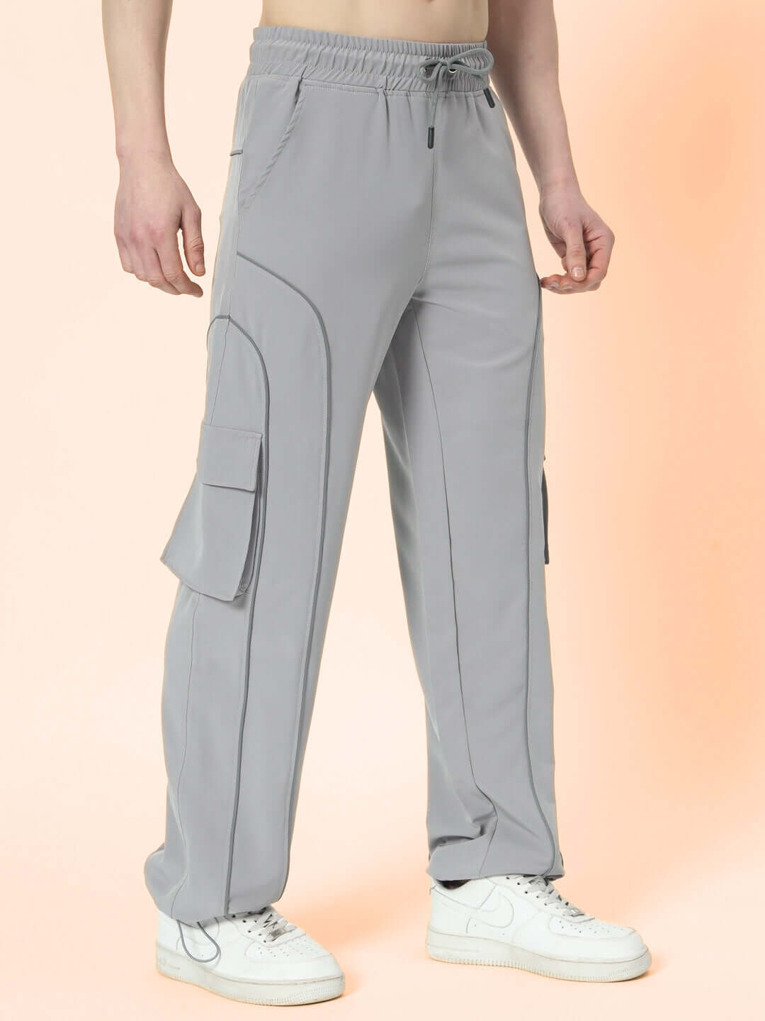 Model wearing grey Ray Reflector Parachute Cargo Pants with pockets, customizable size options available, stylish and comfortable fit.