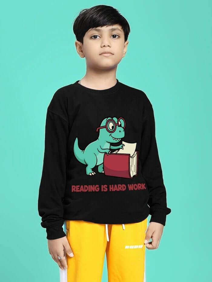 Boy wearing READING HARD PRINTED SWEATSHIRT FOR BOYS GIRLS BLACK with dinosaur book graphic on front, perfect for school.
