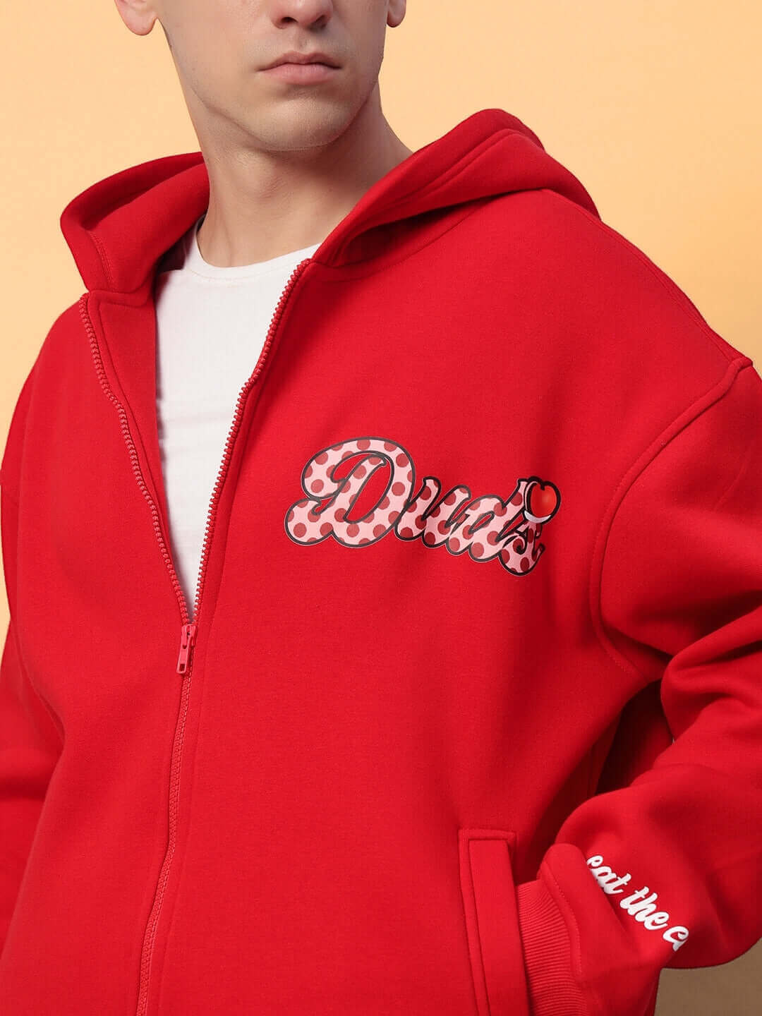 Man wearing CUPCAKE COTTON FLEECE HOODIE RED with bold design and zipper, showcasing trendy streetwear style on a warm cotton fabric.