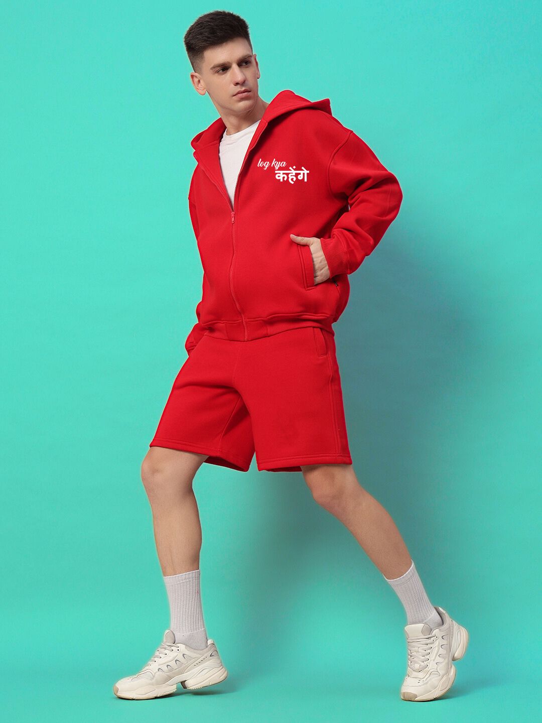 Model wearing A LOOK ATTITUDE FLEECE CO-ORD RED set with shorts and hoodie, showcasing bold style in ultra-soft fleece against a blue background.