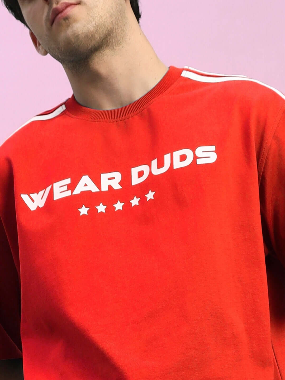 Person wearing red 'WEAR DUDS' sweatshirt with white stripes and star design on the front.