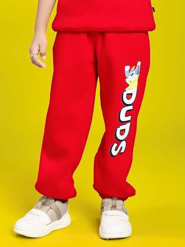 Child wearing HUG WITH THE DOG FLEECE JOGGER FOR BOYS AND GIRLS RED, featuring a dog design and elastic waistband for comfort.