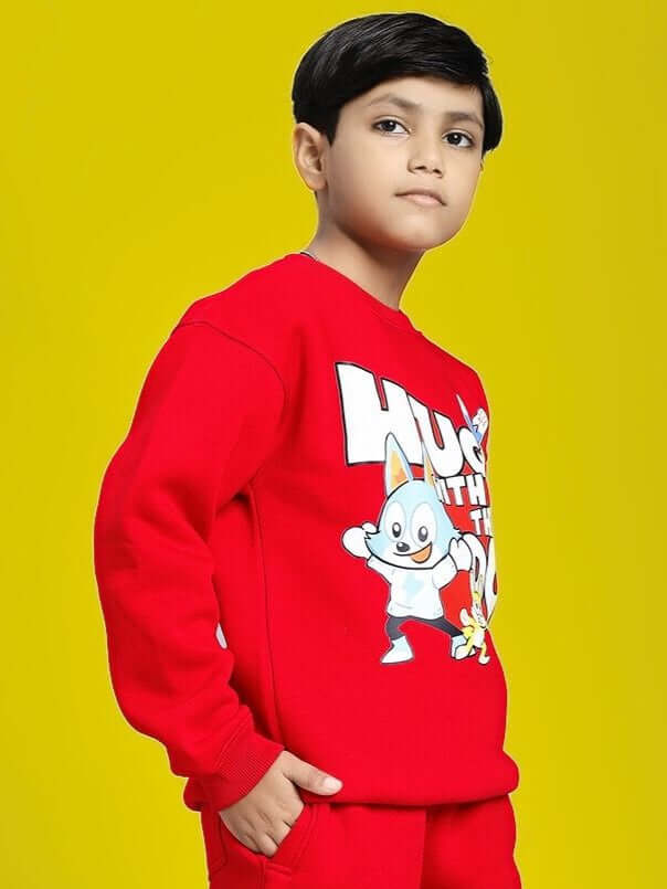 HUG WITH THE DOG FLEECE SWEATSHIRT FOR BOYS AND GIRLS RED with playful dog print, worn by a child against a bright background.