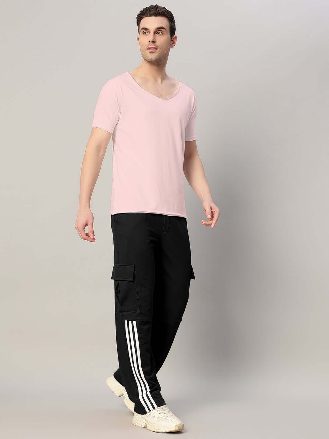 Man wearing REDROIT black relaxed fit joggers with a pink t-shirt, showcasing comfortable style and custom fit options by DUDS.