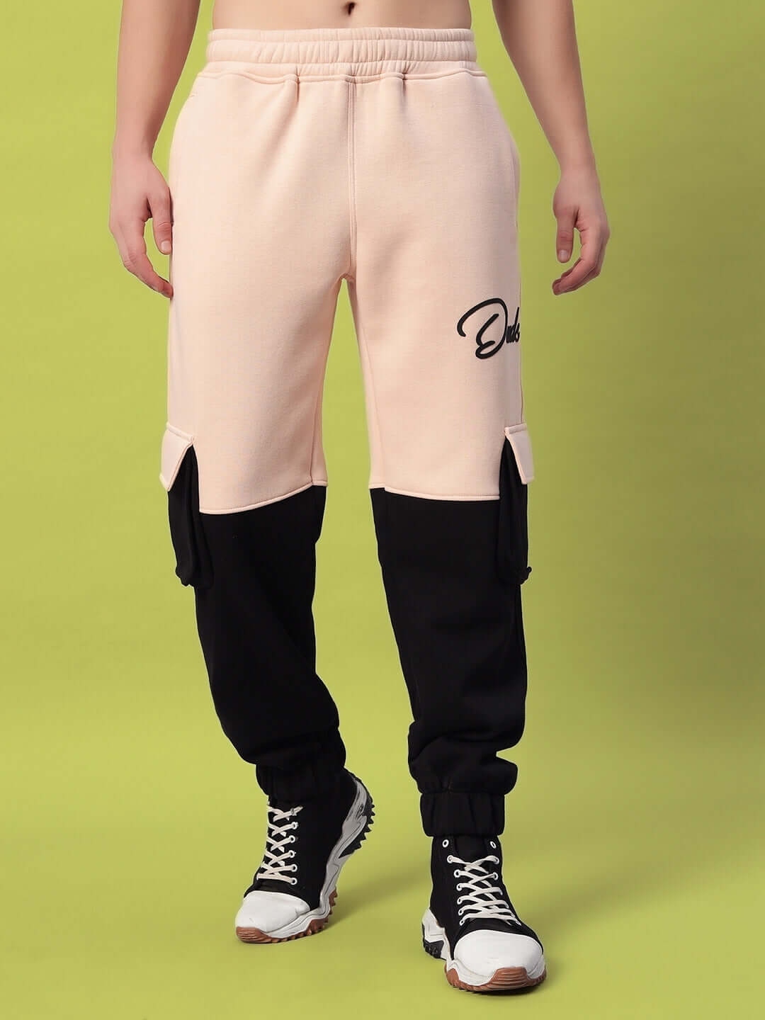 REGIMENT FLEECE PANT BEIGE BLACK with chic beige and bold black detailing shown against a vibrant background.