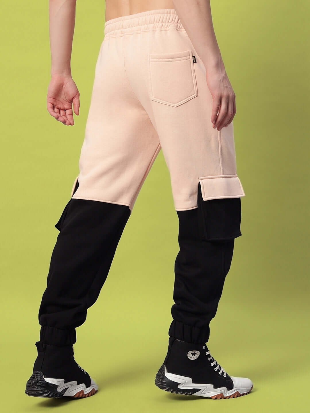 Model wearing REGIMENT FLEECE PANT BEIGE BLACK with beige base and black accents, showcasing contemporary street style.