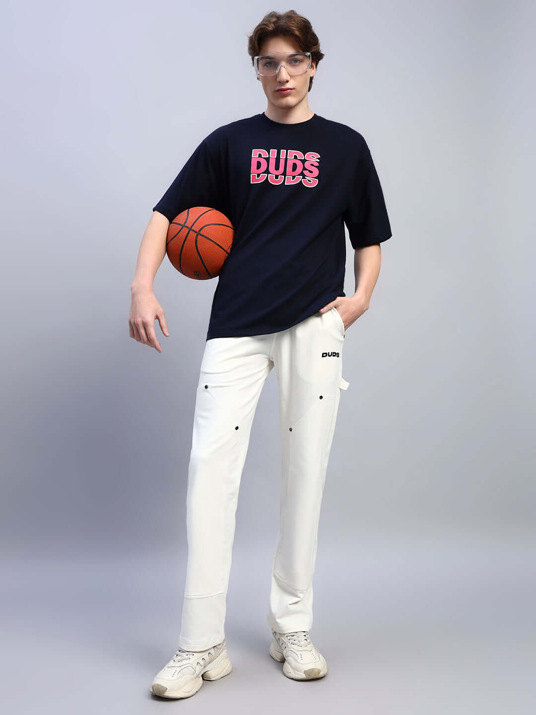 Model wearing REGULUS RELAXED-FIT JOGGERS WHITE with a basketball, showcasing modern streetwear appeal and comfort.