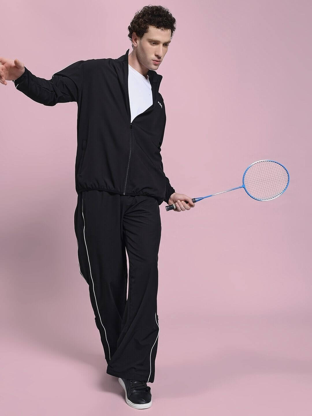Man wearing RELIGHT RELAXED FIT JACKET BLACK with badminton racket in hand