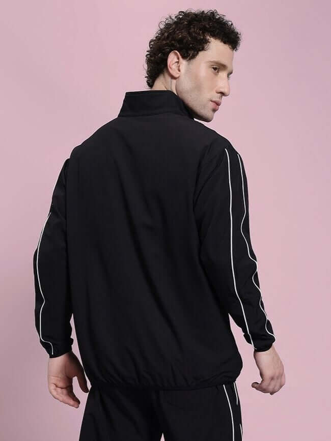 Model wearing RELIGHT RELAXED FIT JACKET BLACK with reflective sleeves, showcasing urban style and functionality.