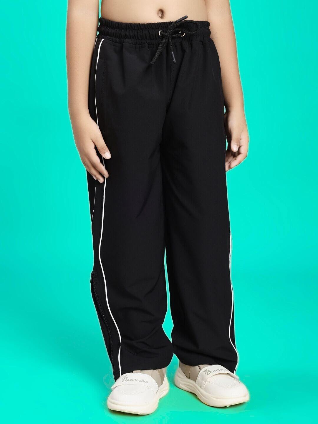 Child wearing RELIGHT RELAXED FIT JOGGER FOR BOYS AND GIRLS BLACK with white sneakers, showcasing comfortable youth fashion.