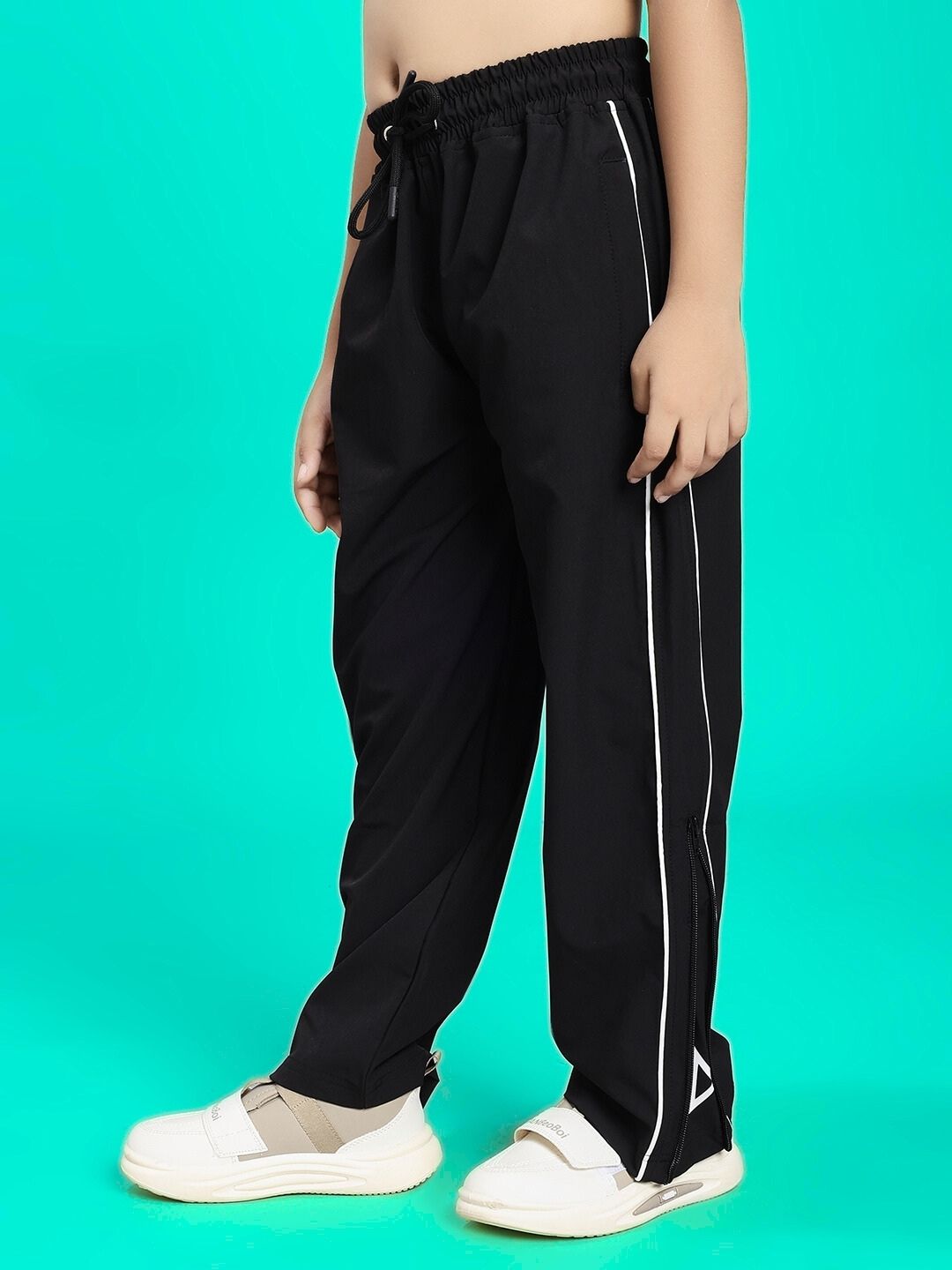 Child wearing RELIGHT RELAXED FIT JOGGER FOR BOYS AND GIRLS BLACK with white stripe detailing.