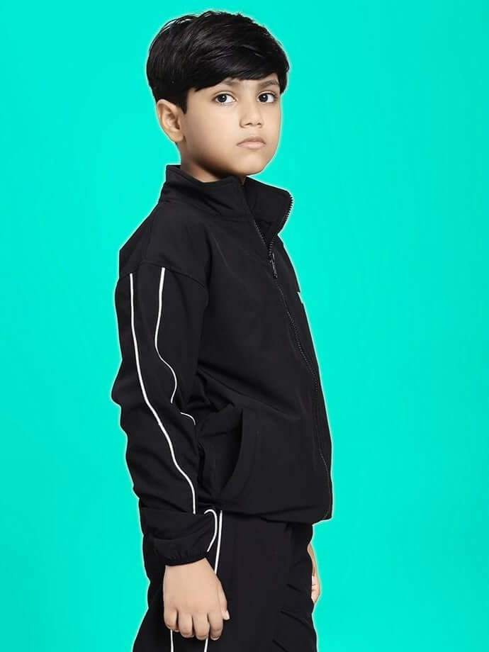 Child wearing RELIGHT RELAXED FIT JACKET FOR BOYS AND GIRLS BLACK on turquoise background