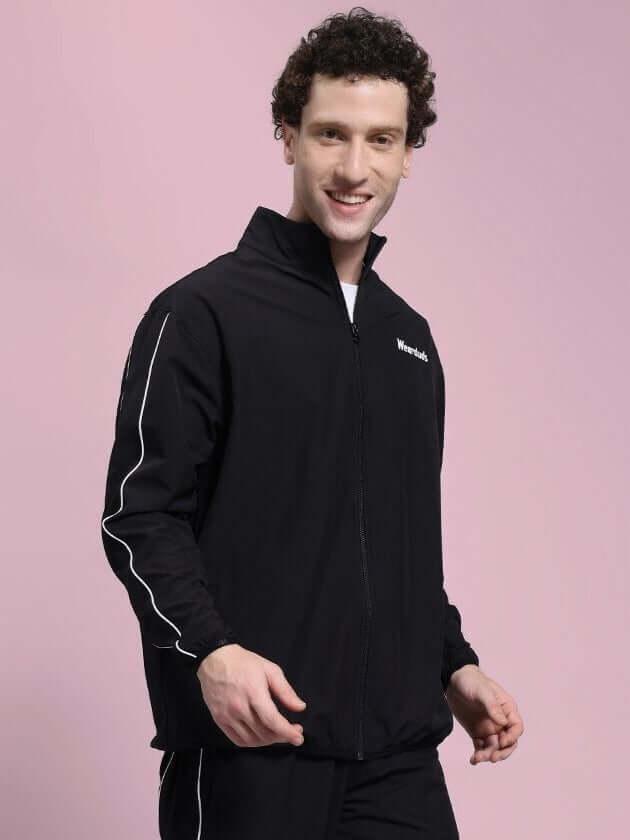 Man wearing RELIGHT RELAXED FIT JACKET BLACK with reflective trims, showcasing modern style and functionality for urban and active use.