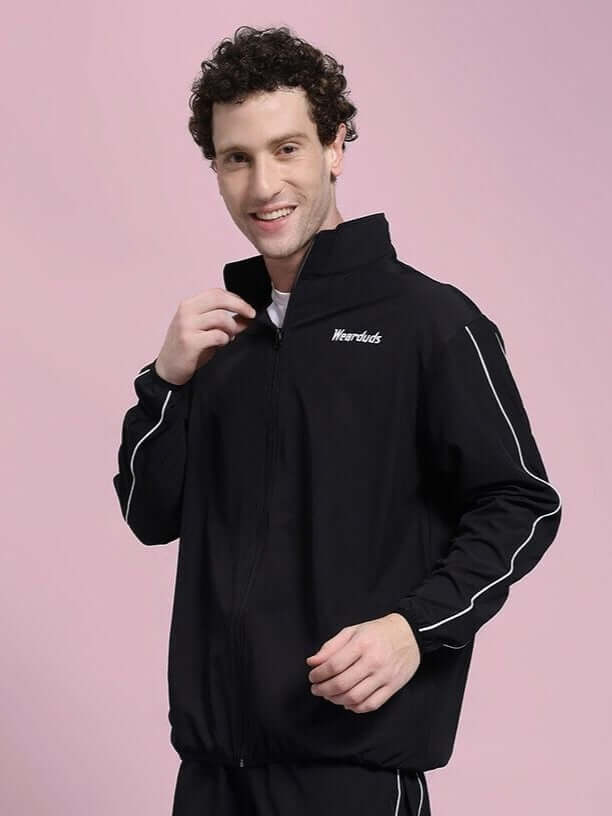 Person wearing the RELIGHT RELAXED FIT JACKET BLACK with reflective trims, showcasing modern style and comfort.