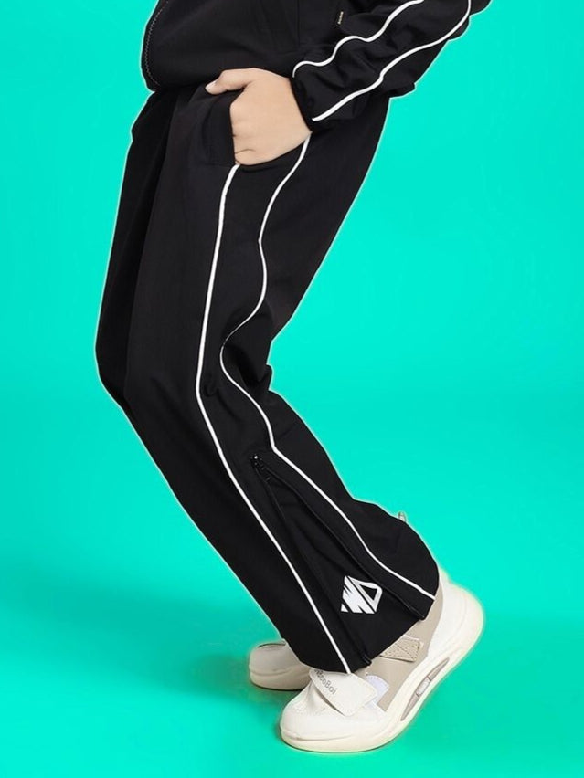 RELIGHT RELAXED FIT JOGGER FOR BOYS AND GIRLS BLACK with white stripes, side view against a turquoise background.