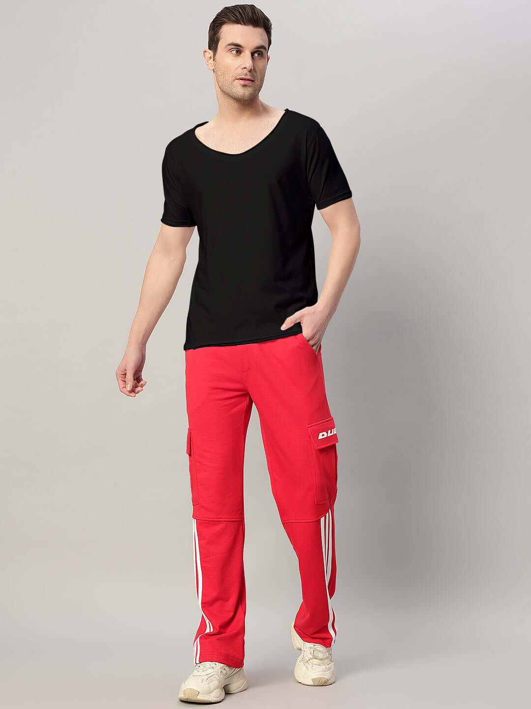 Man wearing RICKY REGULAR FIT T-SHIRT BLACK with red pants, showcasing casual style and comfort.