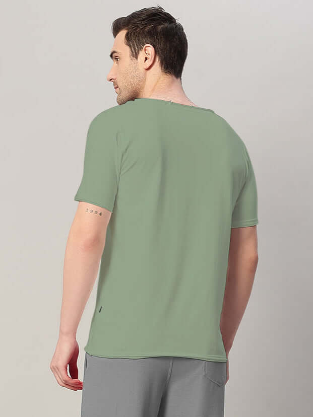 Back view of a model wearing RICKY REGULAR FIT T-SHIRT SAGE GREEN, showcasing the relaxed and refined silhouette.