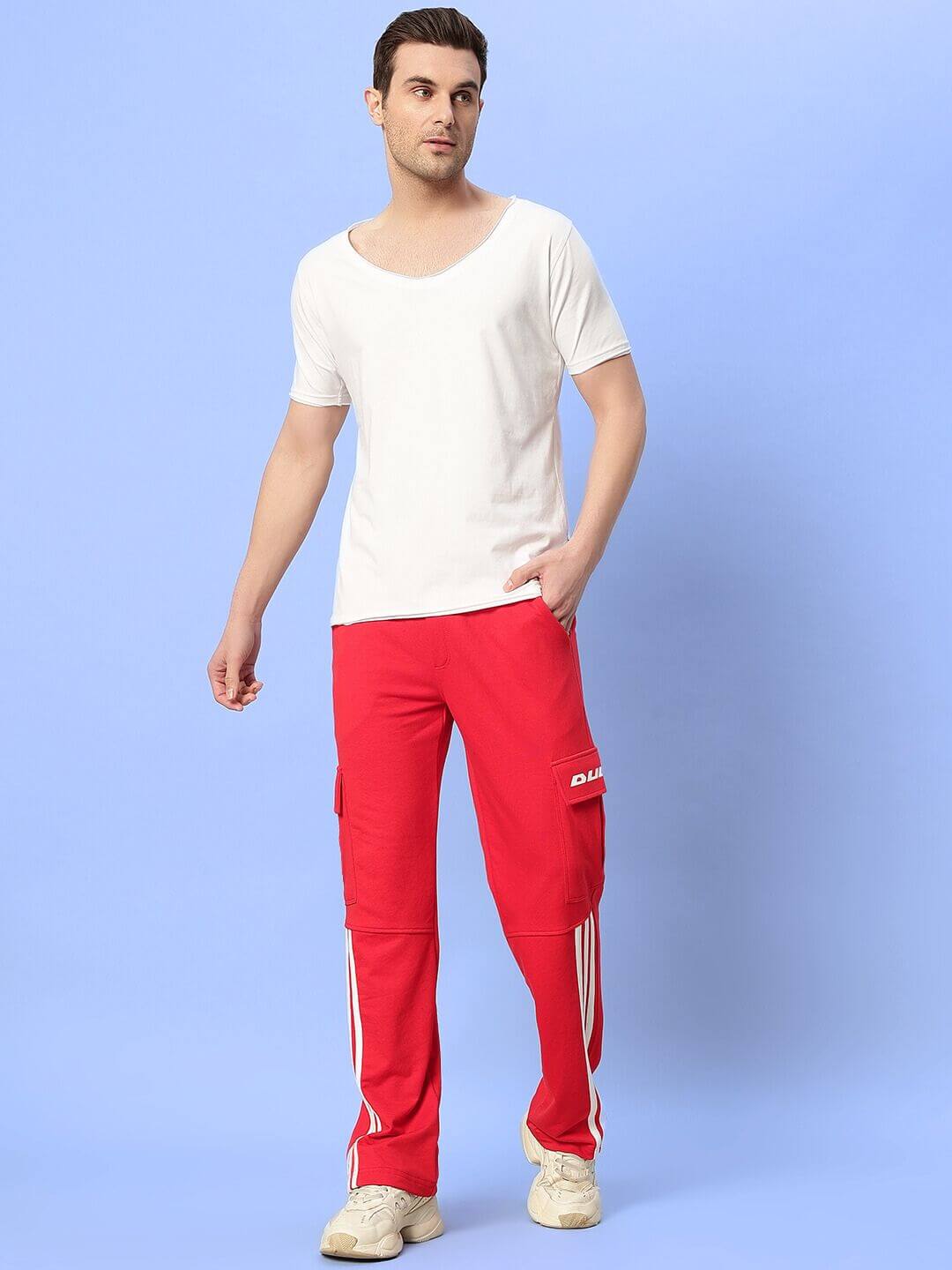 Model wearing Ricky Relaxed Fit Co-Ord Set in white and red, featuring unisex joggers with drawstring and contrast panels. Premium cotton blend.