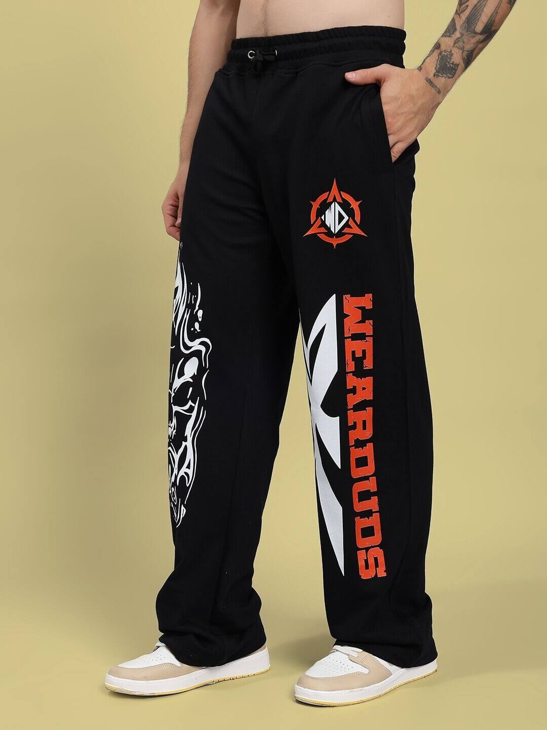 Man wearing RIFT RELAXED FIT JOGGER IN BLACK with graphic design on legs, showcasing comfortable and stylish casual wears