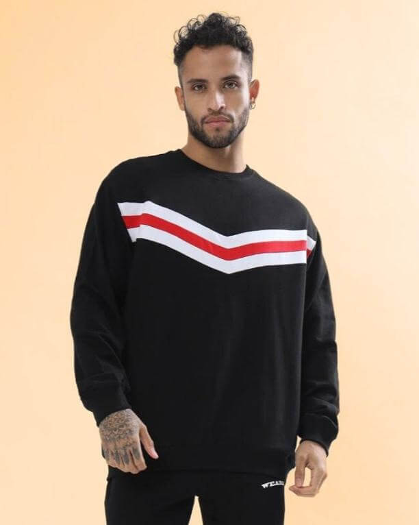 Man wearing RIGHTMAN oversized co-ord set with red and white contrast panel on black sweatshirt.