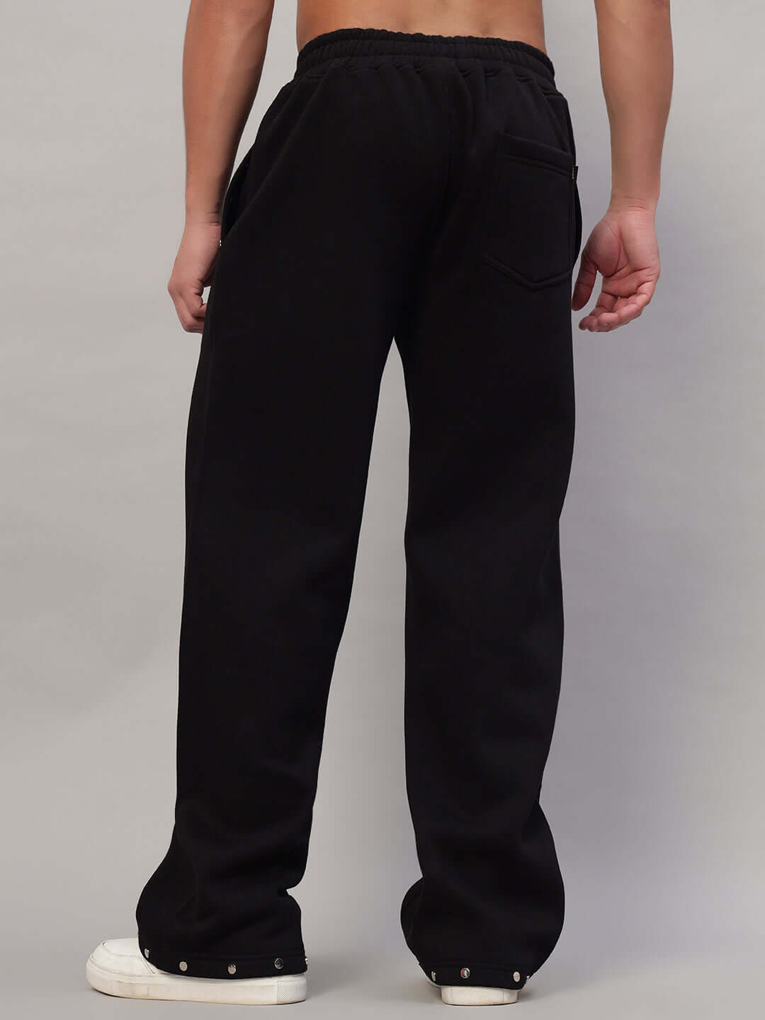 Back view of black rigid cotton fleece jogger with elastic waistband and side pocket, perfect for casual wear and comfort.
