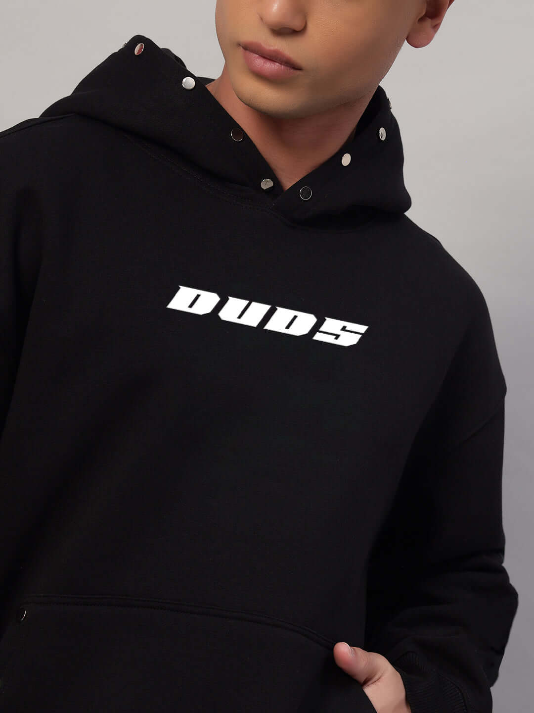 Person wearing WEARDUDS RIGID FLEECE HOODIE BLACK, featuring 'DUDS' logo, stylish custom-fit option available.