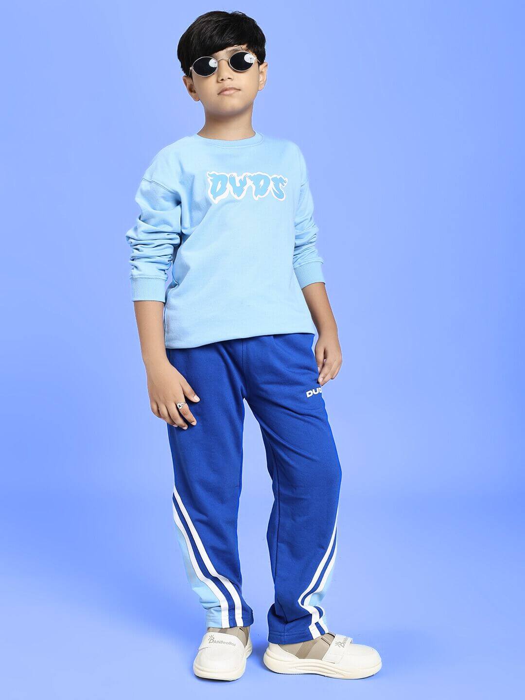 Boy wearing RIO ONE RELAXED FIT JOGGER FOR BOYS AND GIRLS BLUE with casual outfit in a studio setting.