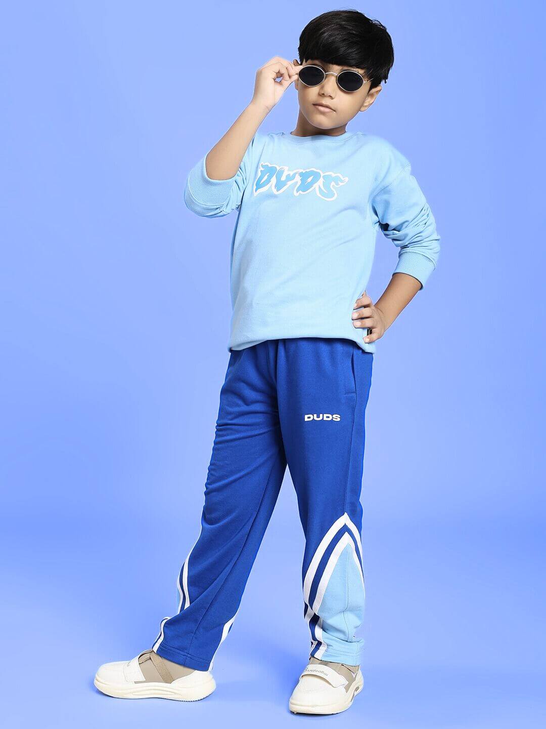 Child wearing RIO ONE RELAXED FIT JOGGER FOR BOYS AND GIRLS BLUE, stylish and comfortable casual kids' wear.