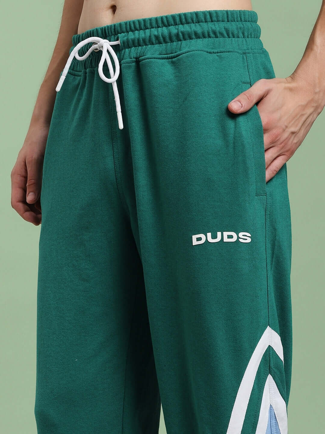 Man wearing RIO ONE RELAXED FIT JOGGERS TEAL GREEN showcasing style and comfort with elastic waist and bold teal color.