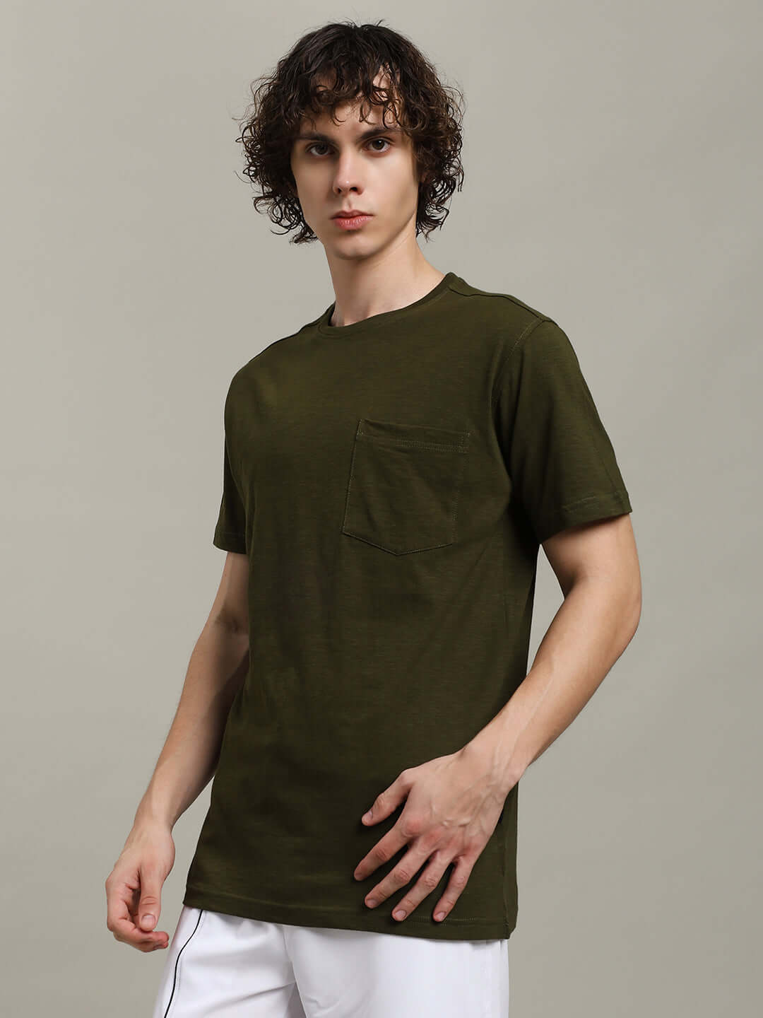 Model wearing ROBAR olive T-shirt in premium cotton slub fabric, showcasing regular fit and front pocket, made in India.