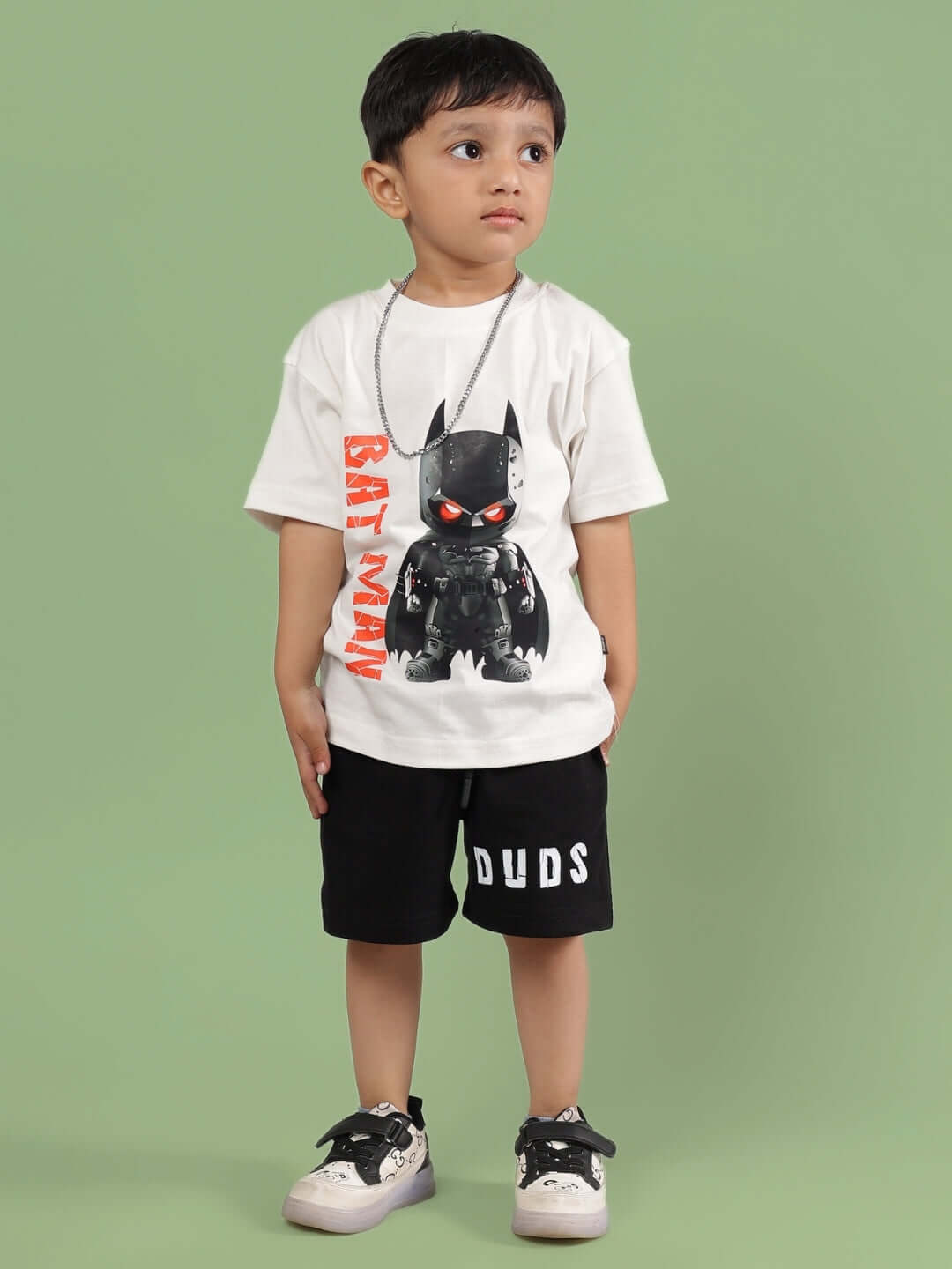 Child wearing ROBIN CO-ORD FOR BOYS & GIRLS OFF WHITE-BLACK by DUDS, featuring a graphic t-shirt and shorts. Made to order with custom fit options.