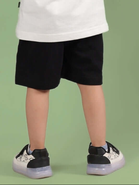 Child wearing ROBIN SHORTS FOR BOYS & GIRLS BLACK, showcasing comfortable and stylish design ideal for all genders.