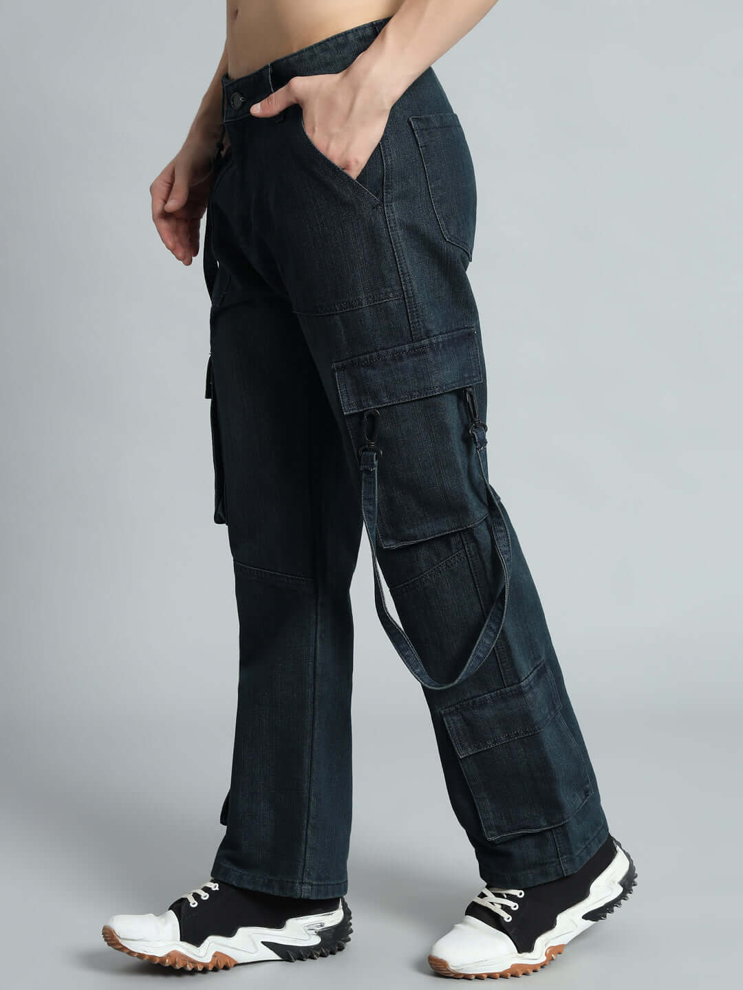 Model wearing Rockie Relaxed Denim Cargo Pants in blue with side pockets and sporty sneakers.