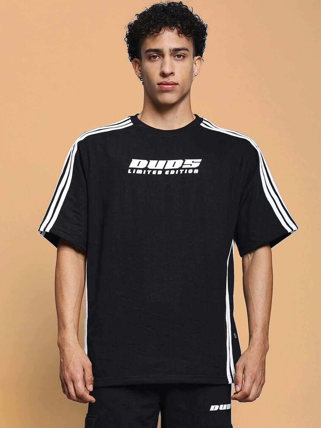 Man wearing Roddy Over-Sized Classic T-Shirt Black with white stripe details, showcasing modern streetwear fashion.