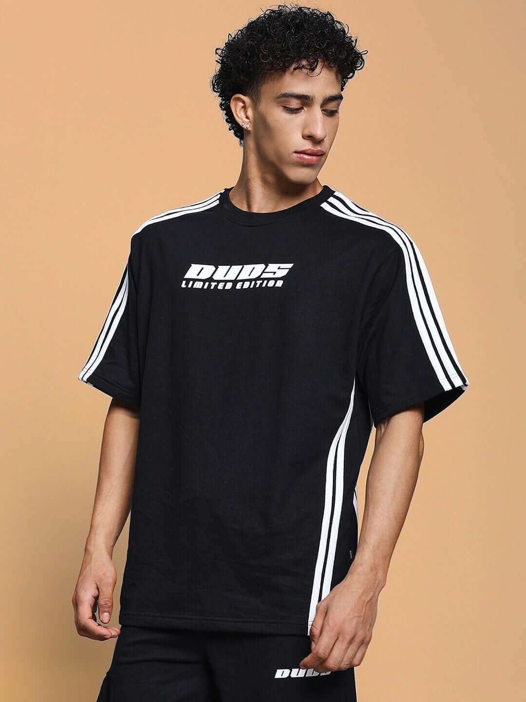 Model wearing RODDY OVER-SIZED CLASSIC T-SHIRT BLACK with white stripe details, embodying modern streetwear style.