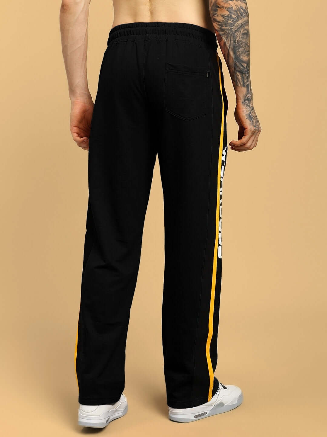 Back view of ROGER RELAXED-FIT JOGGERS BLACK with side stripe design, showcasing relaxed fit and style.