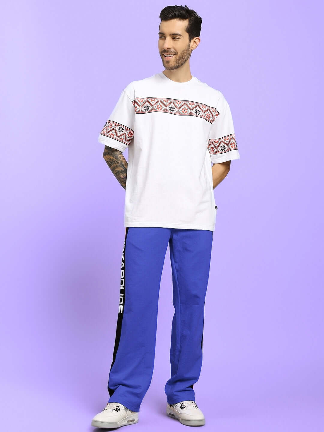 Model wearing ROGER RELAXED-FIT JOGGERS BLUE paired with casual white t-shirt on pastel background.