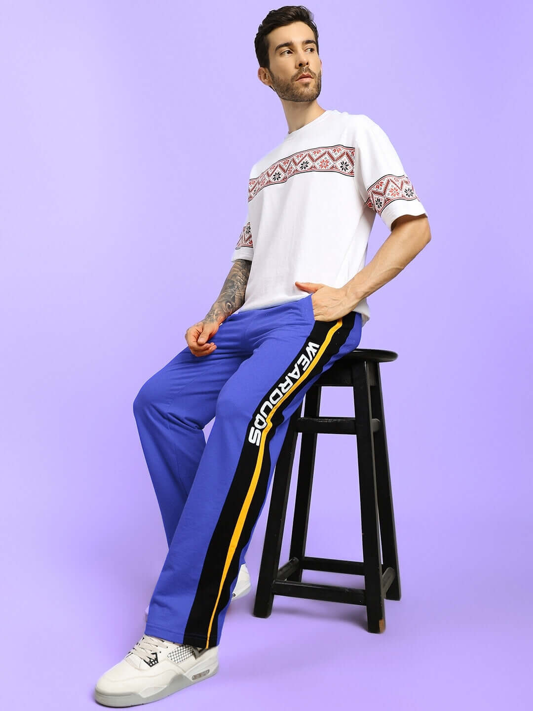 Man wearing ROGER RELAXED-FIT JOGGERS BLUE sitting on a stool
