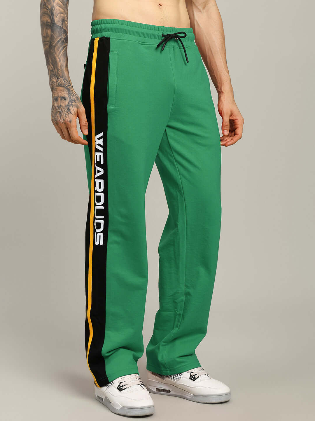 Man wearing ROGER RELAXED-FIT JOGGERS GREEN with stripe detail and drawstring waistband.