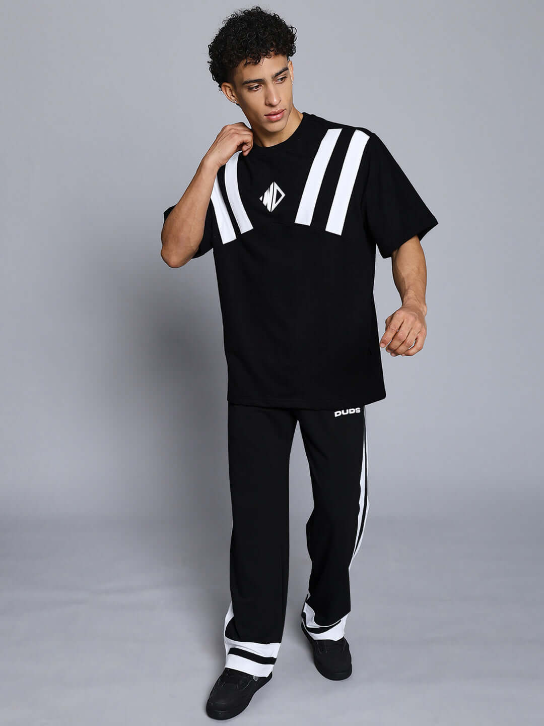 Model wearing RONNY SIDE STRIPE JOGGER in black and white with DUDS branding, showcasing custom fit options.