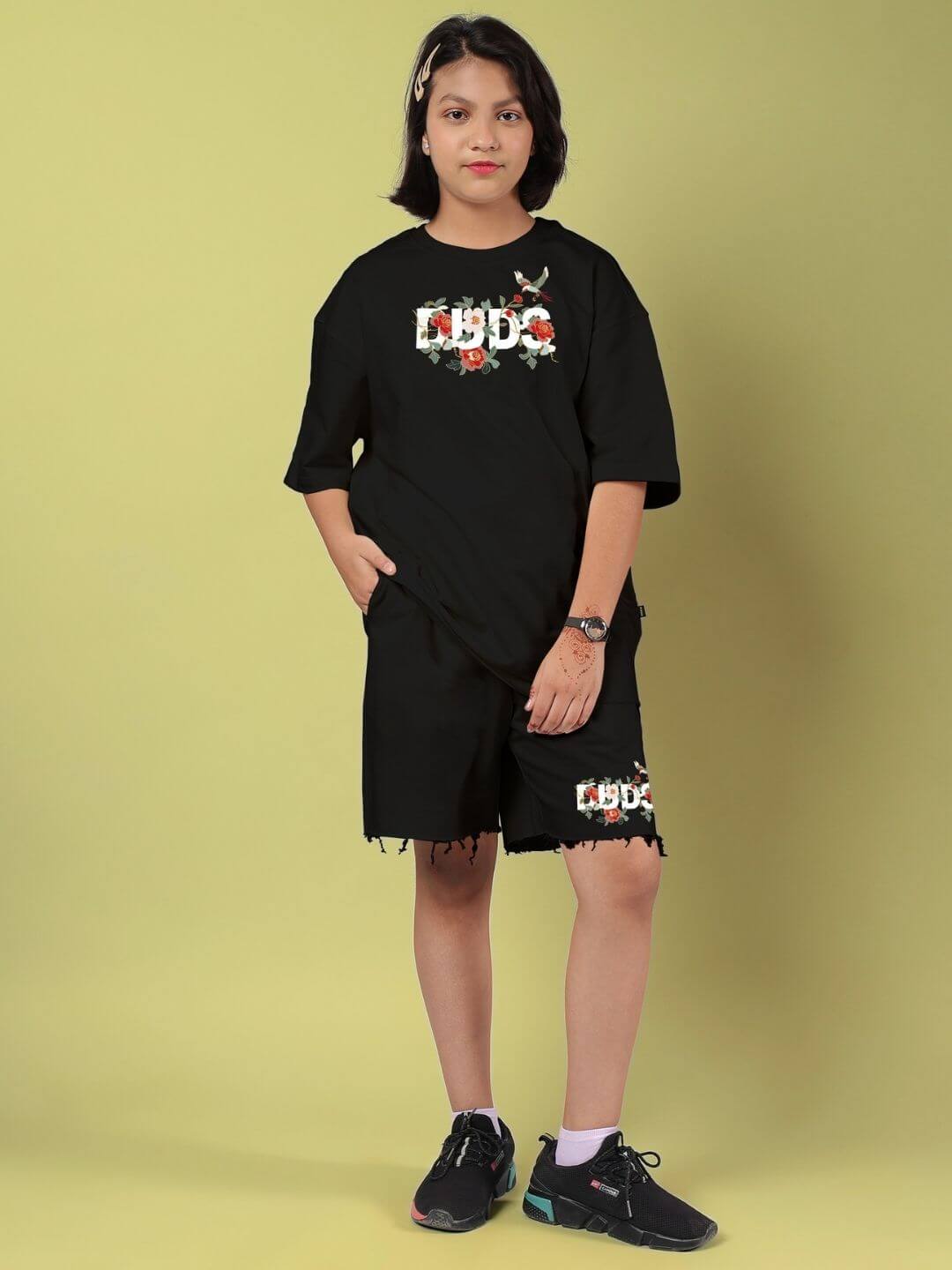 Young person wearing ROSE CHARM CO-ORD FOR BOYS AND GIRLS BLACK with rose detail, showcasing unisex streetwear style.