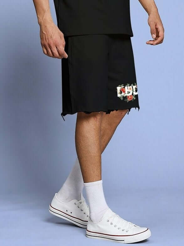 ROSE CHARM RELAXED FIT SHORTS BLACK shown on model with white sneakers, highlighting comfortable and stylish fit.
