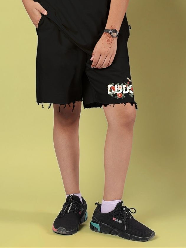 ROSE CHARM SHORTS FOR BOYS AND GIRLS BLACK worn, featuring floral design on black fabric, perfect for casual outings.
