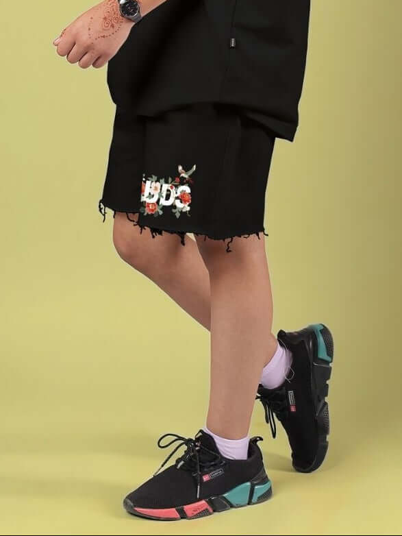 ROSE CHARM SHORTS FOR BOYS AND GIRLS BLACK worn by child, showcasing edgy design and signature rose detail.